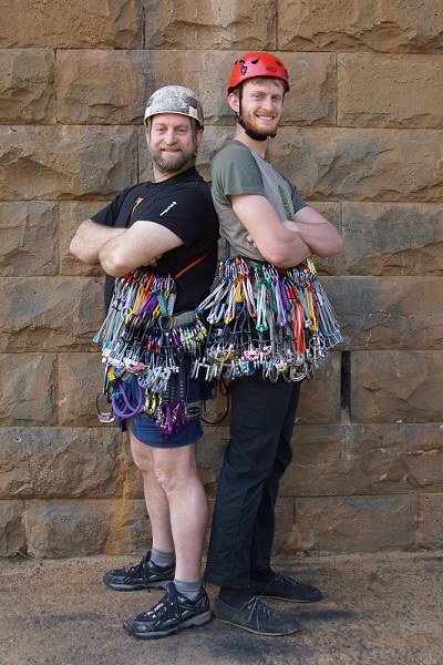 Steve Morris and John Morris post in front of a stone wall in full climbing gear